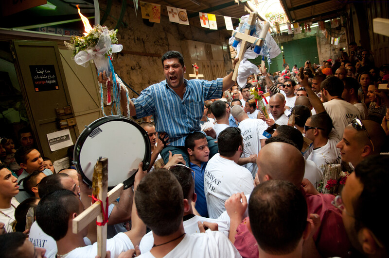 Crowd holds crosses and drums during holy fire ceremony