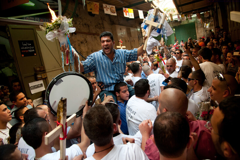 Crowd holds crosses and drums during holy fire ceremony