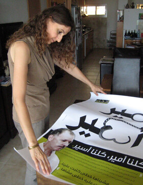 Janan Abdu looks at poster of jailed husband Ameer Makhoul