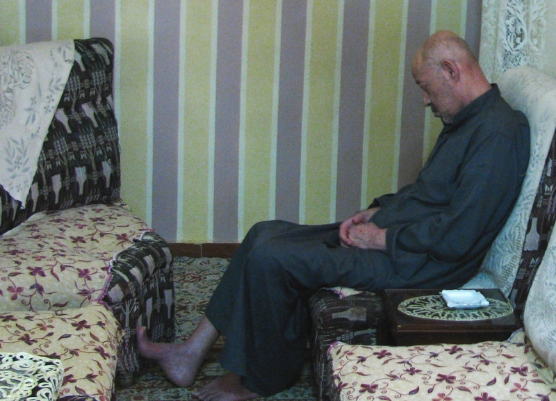 Forlorn-looking man sits in living room