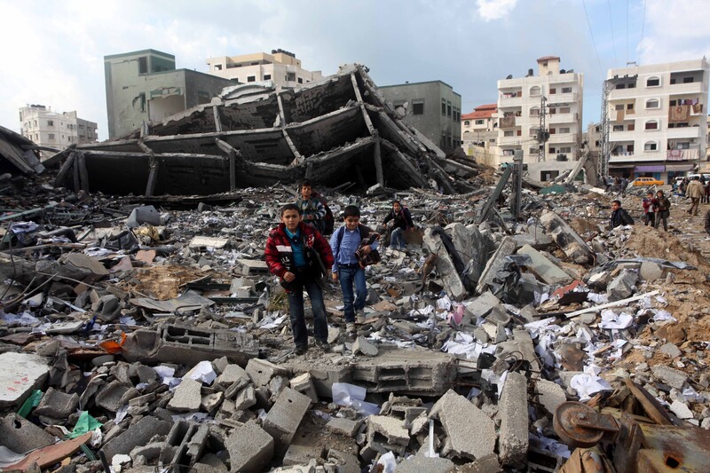 Two boys standing in the middle of rubble