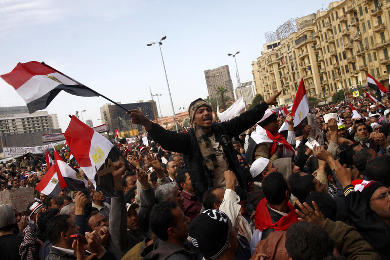Man in crowd waves Egyptian flag