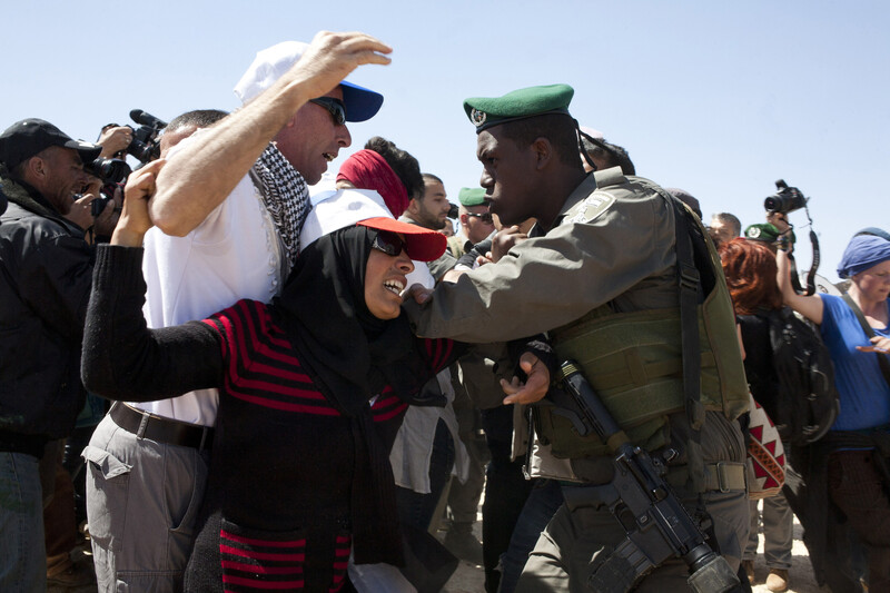 Woman attempts to stop a soldier from arresting man