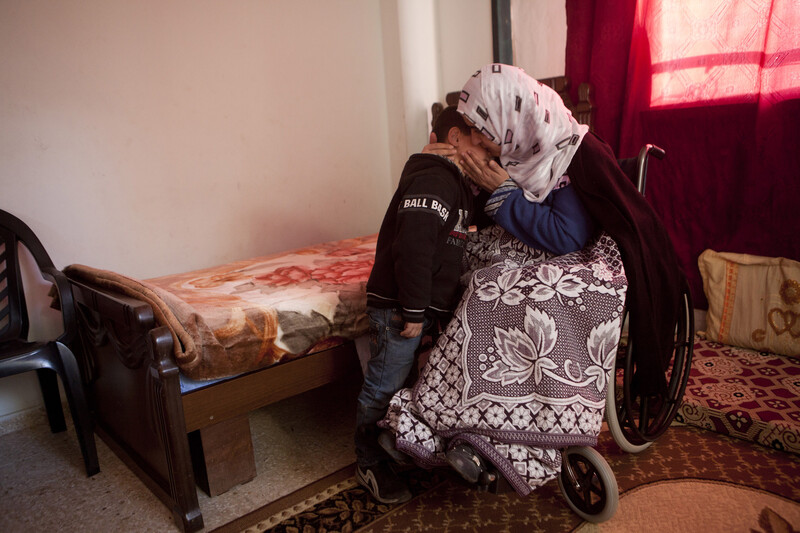 Women embraces son in their residence