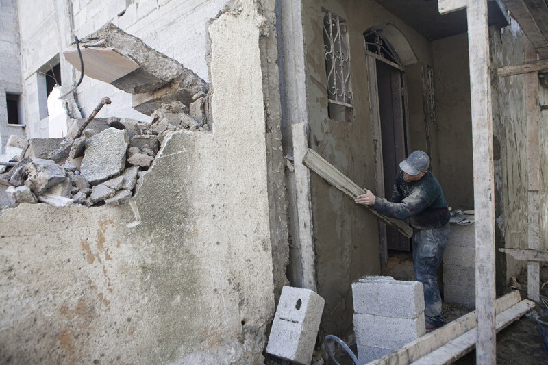 Laborer covered in dust holds up board