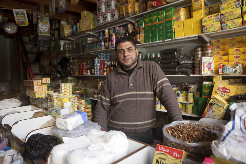 Man stands surrounded by grocery goods