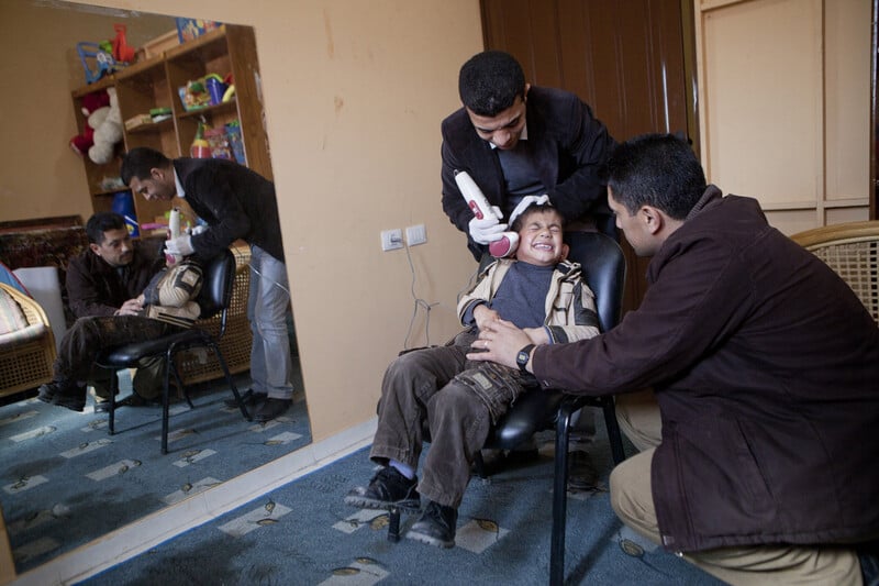 Boy winces as device is used on his face