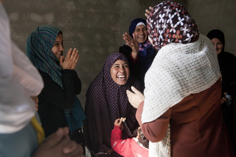 Women laugh and clap together