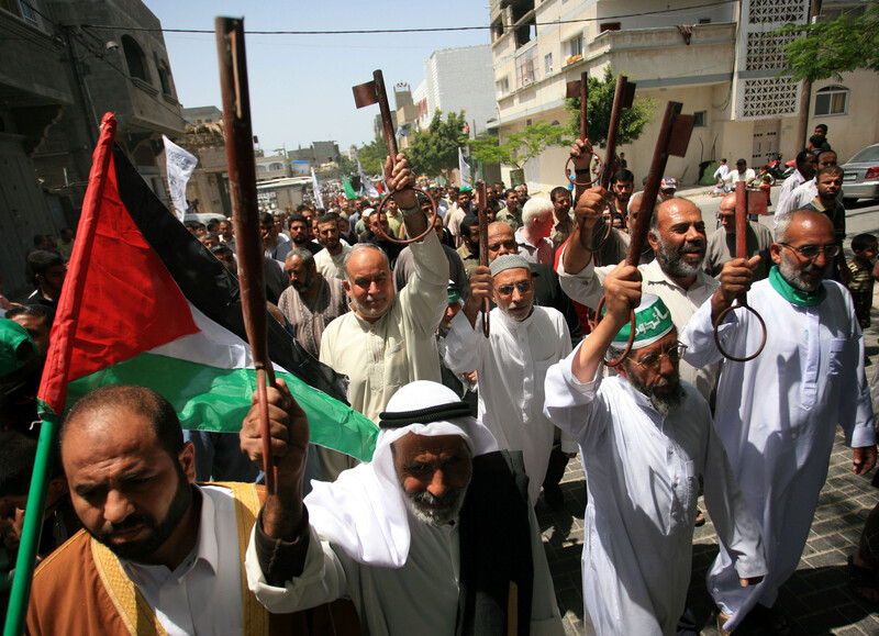 Men in white tunics carry oversized keys