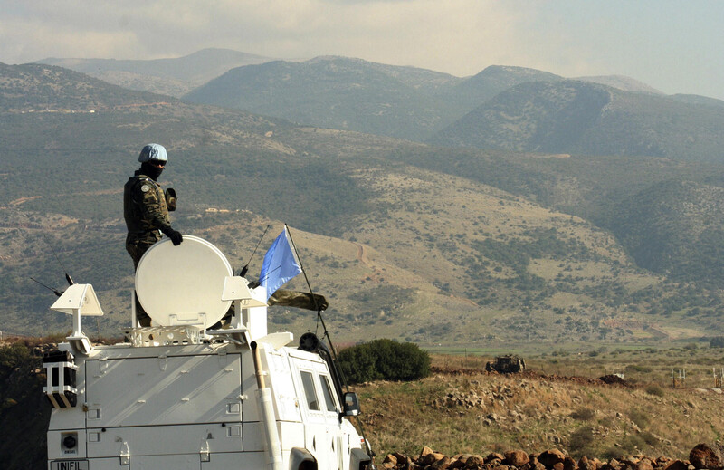 UN soldier atop armored vehicle overlooks Lebanon-Israel border