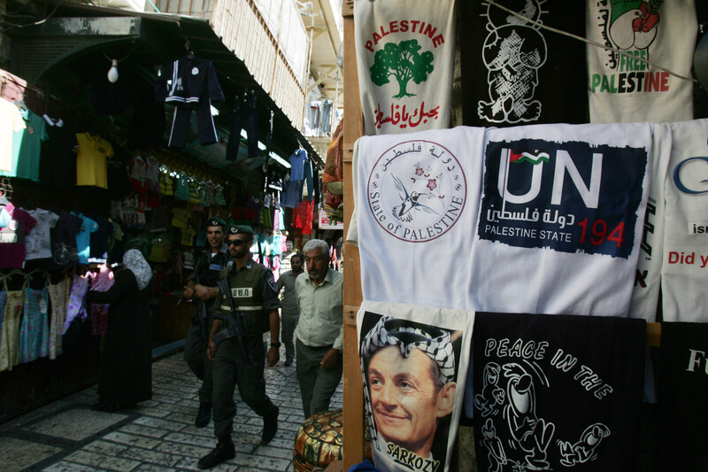 Israeli police walk by display of T-shirts marketed to tourists