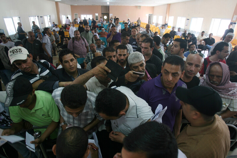 Men holding passports crowd at crossing terminal