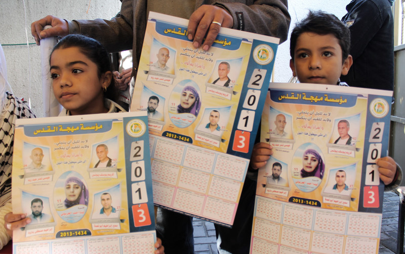 Children hold calendars with photos of political prisoners