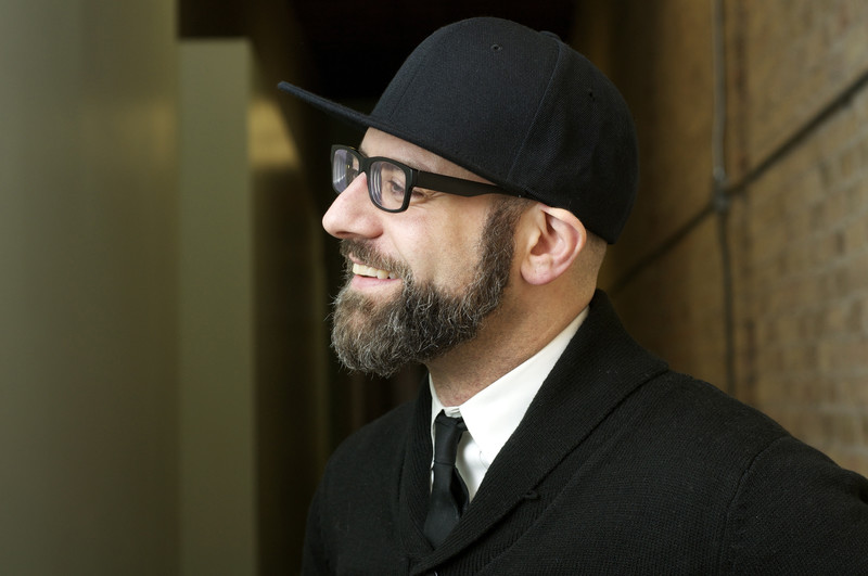 Portrait photograph of bearded man wearing cap