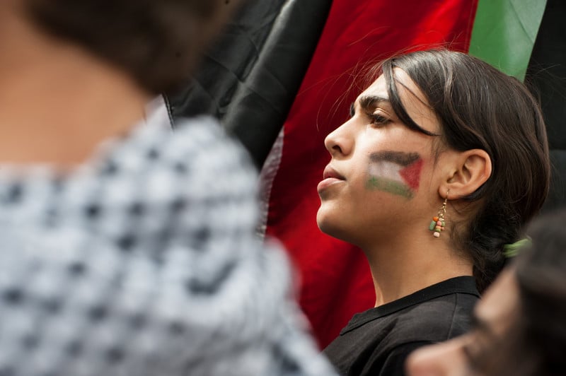 Portrait of girl with flag of Palestine painted on her face