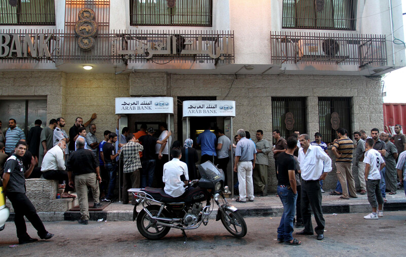 Men queue in front of bank building