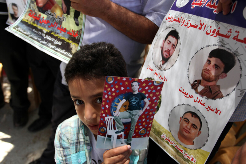 Close-up of youth holding portrait of young man at prisoner solidarity rally