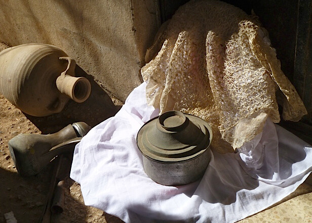 Vessels and pots sit on fabric