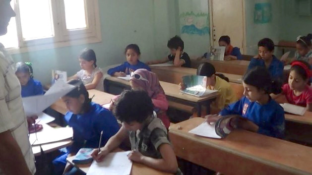 Children sit at school desks