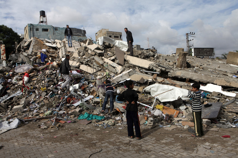 Children gather on rubble of building hit in Israeli air strike