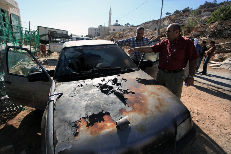 Man gestures towards scorched car