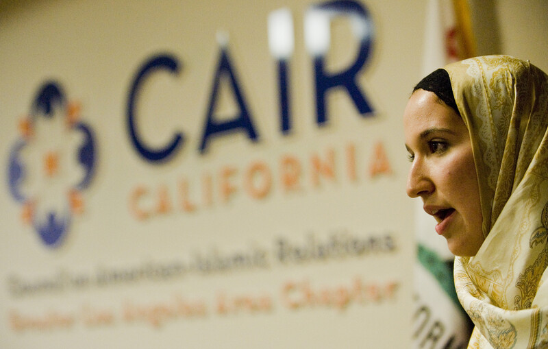 Woman stands in front of Council on American-Islamic Relations sign