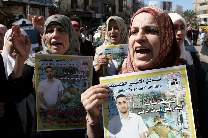 Women march and hold posters of political prisoners