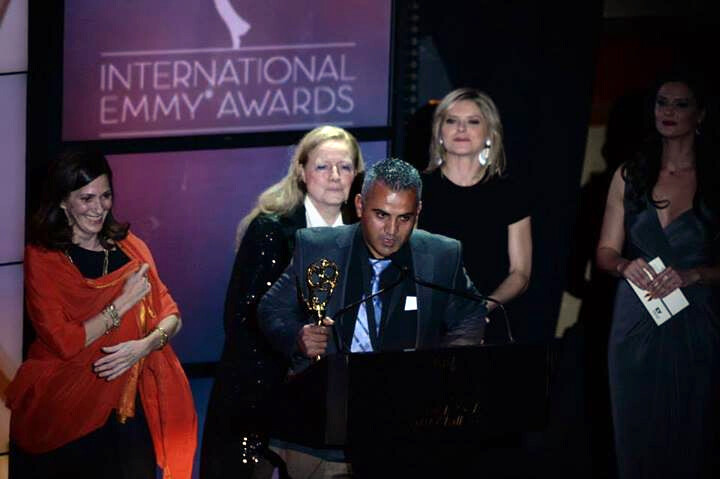 Man makes speech at podium while holding award