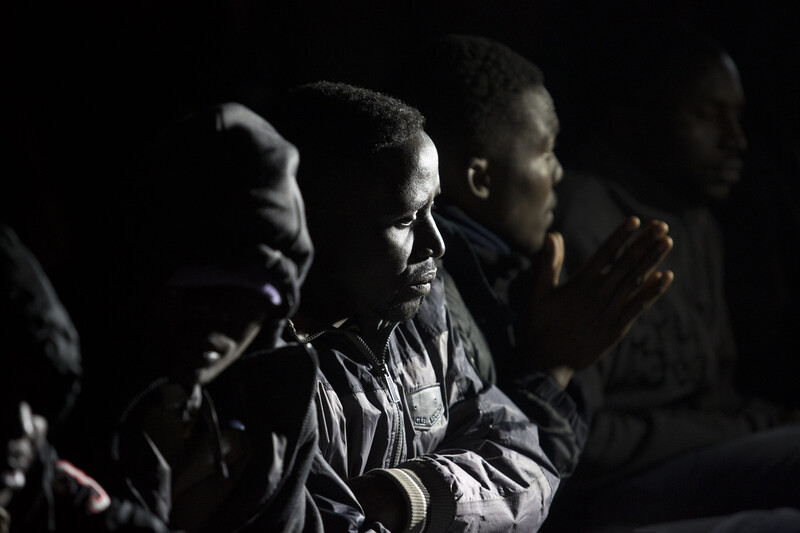 Close-up of men wearing winter coats sitting at night