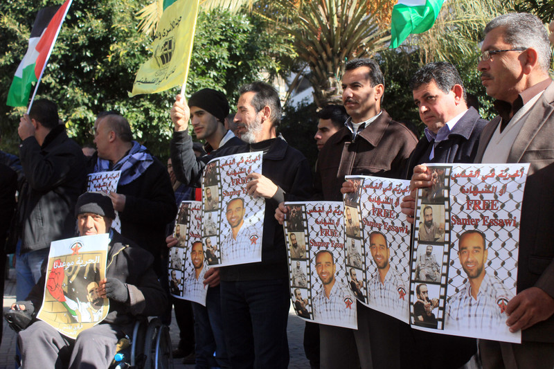 Men hold posters of Palestinian prisoner
