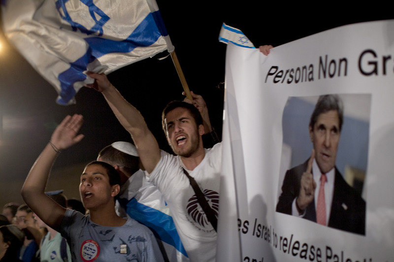 Young people wave Israeli flags during nighttime rally