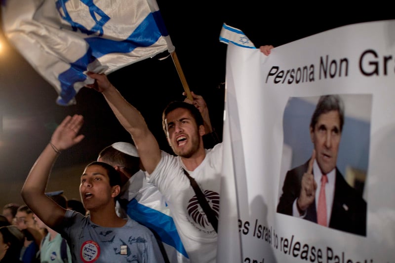 Young people wave Israeli flags during nighttime rally