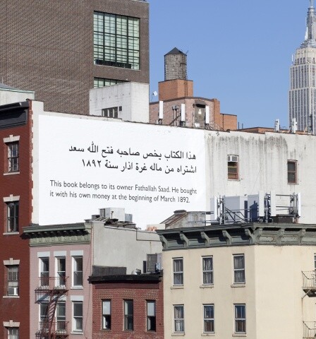 View of text painted on side of building reading: This book belongs to its owner Fathallah Saad. He bought it with his own money at the beginning of March 1892.