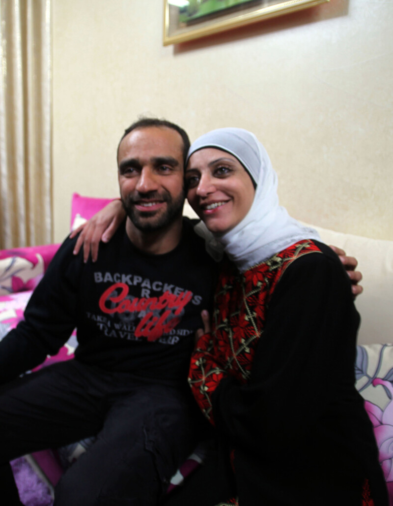 Smiling woman wearing traditional dress hugs young man