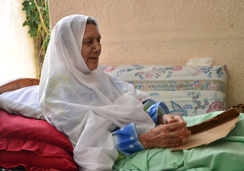 Elderly woman sits in bed