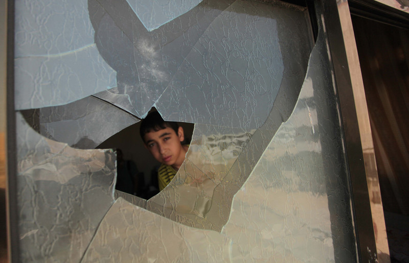 Boy peers through broken window