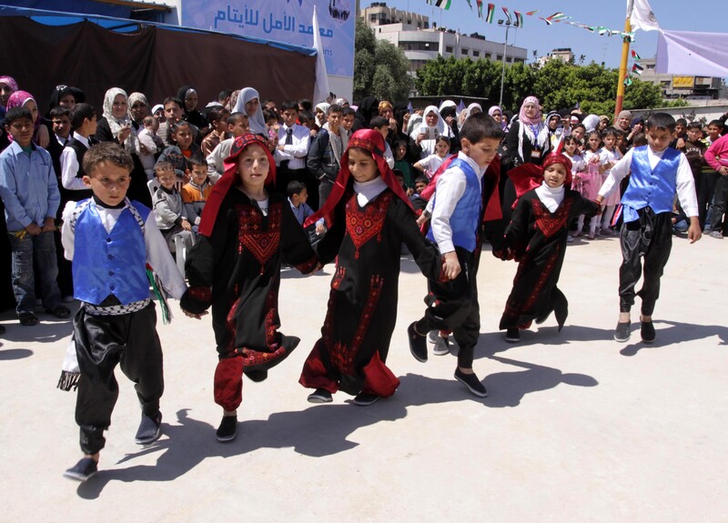 Boys and girls hold hands while performing a line dance