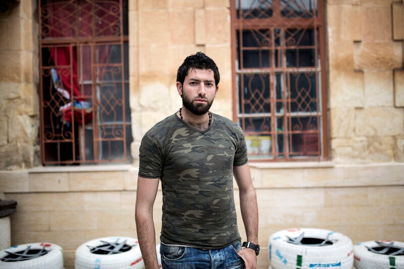 Young man stands outside building