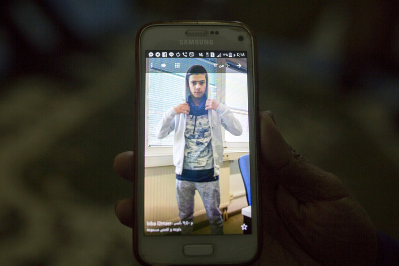 Close-up of phone displaying image of youth