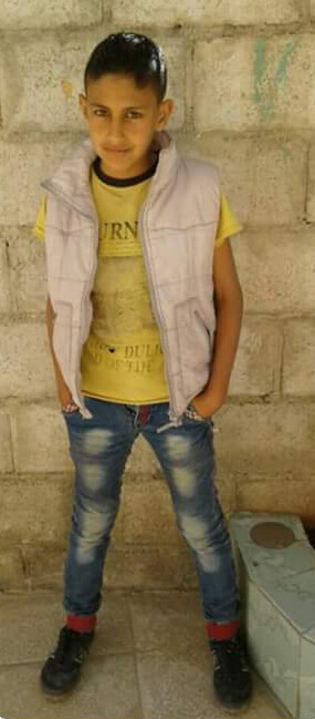 Smiling boy stands in front of wall