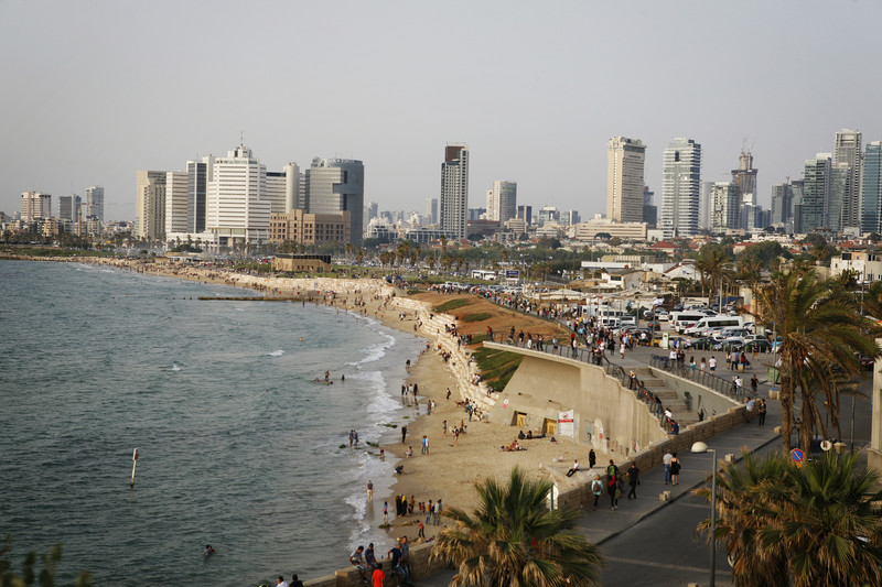 Landscape view of sea and beach surrounded by city skyline