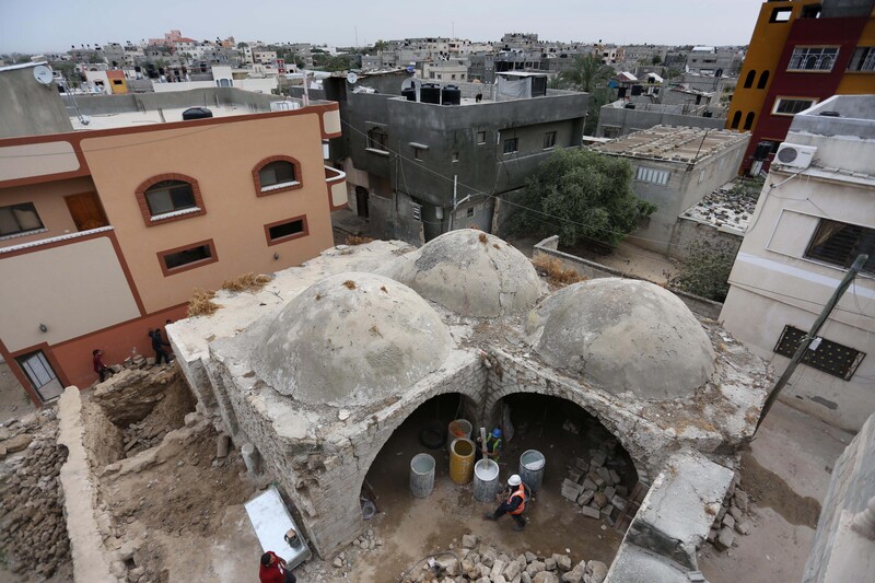 Landscape view of trio of connected domed structures next to modern buildings