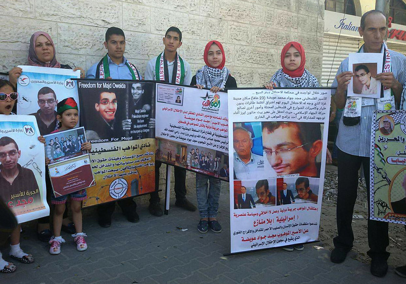Adults and children carry posters calling for freedom for Majd Oweida