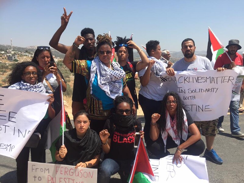 People holding signs and Palestinian flags