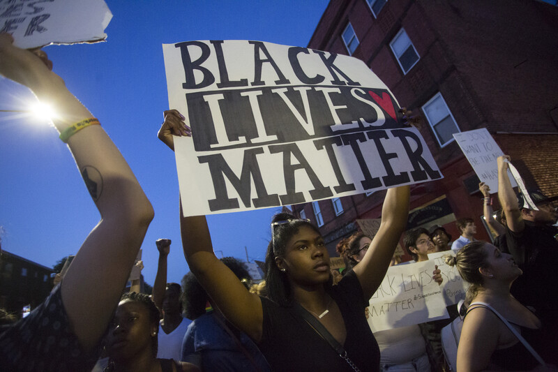 Woman holds sign reading Black Lives Matter during demonstration