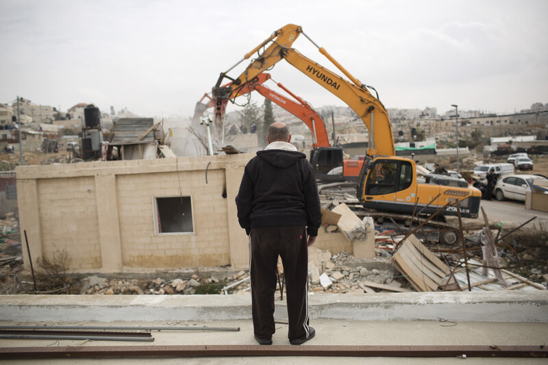 Man watches as heavy equipment is used to destroy home