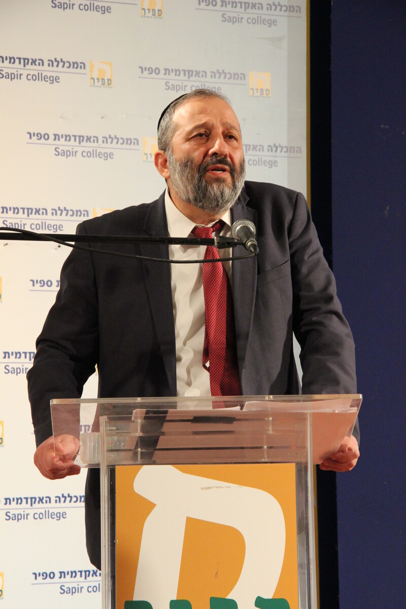 Aryeh Deri speaks at a podium