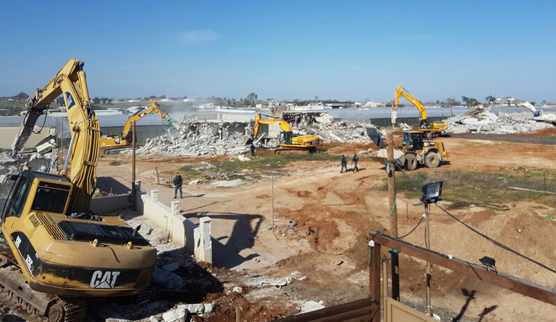 Landscape view of Caterpillar machines demolishing several homes