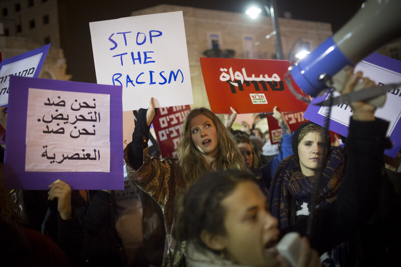 Protesters carry signs against racism