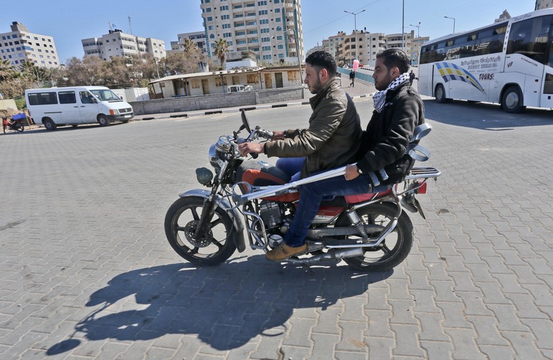 Two young men sit on motorcycle